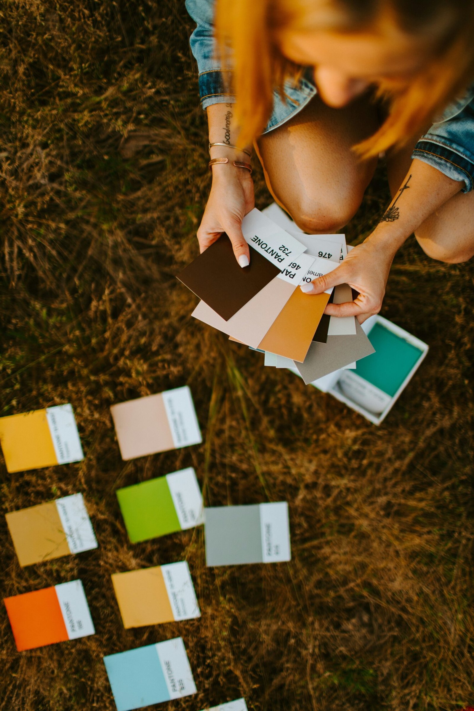 woman in blue denim shorts sitting on green grass field